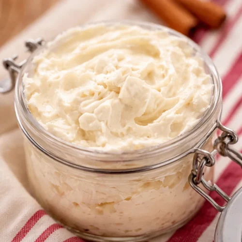 Whipped gingerbread body butter in a glass jar, showcasing creamy texture and holiday scent.